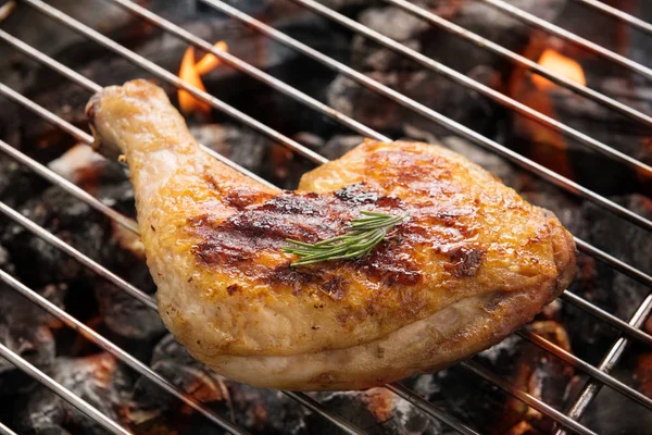 Patada de pollo a la parrilla sobre llamas en una barbacoa — Foto de Stock