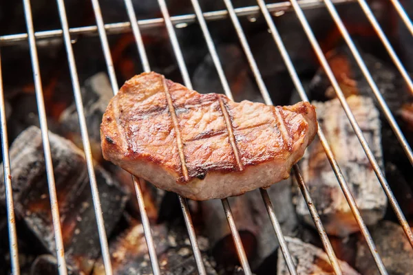 Filetes de cerdo a la parrilla sobre llamas en la parrilla — Foto de Stock