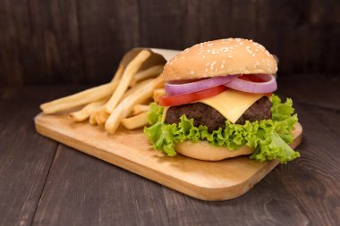 Çizburger ahşap arka plan üzerinde patates kızartması ile