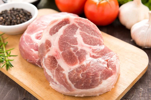 Surowe mięso na deski do krojenia i czosnek, pieprz na drewniane bac — Zdjęcie stockowe
