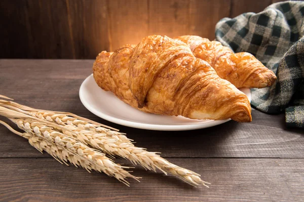The breakfast croissant on the wooden table — Stock Photo, Image