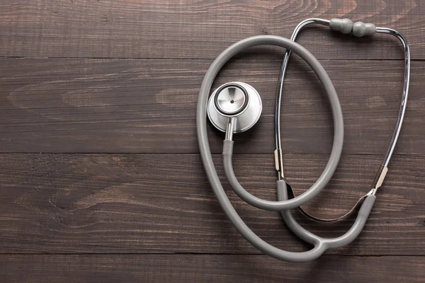 Stethoscope on wooden desk background. Top view — Stock Photo, Image