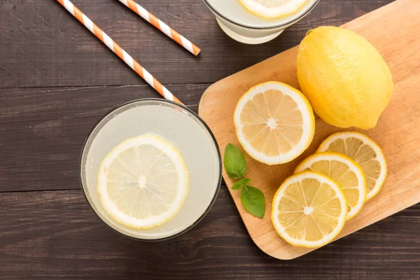 Limonada con limón fresco en rodajas sobre fondo de madera —  Fotos de Stock