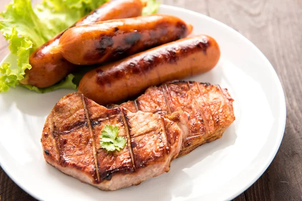 М'ясо на грилі, сосиски та овочі на страві крупним планом — стокове фото