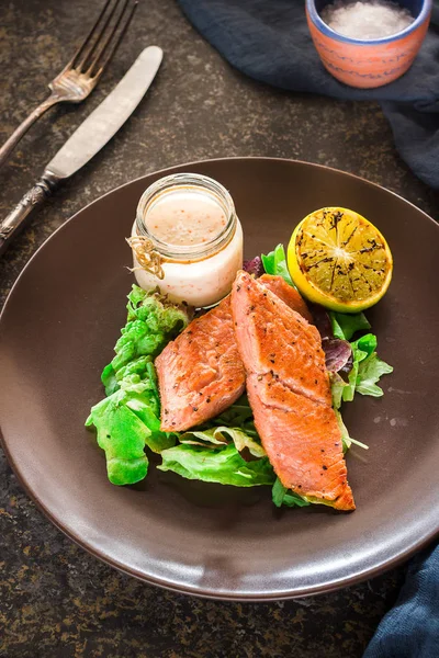 Baked salmon with green and lemon on ceramic plate — Stock Photo, Image