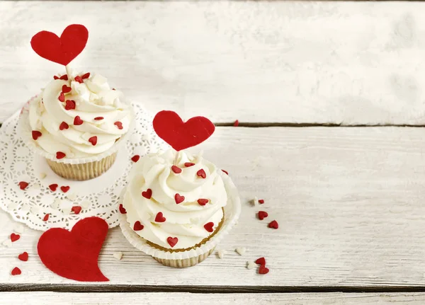 Cupcakes com corações vermelhos para São Valentim Day.White fundo de madeira . — Fotografia de Stock
