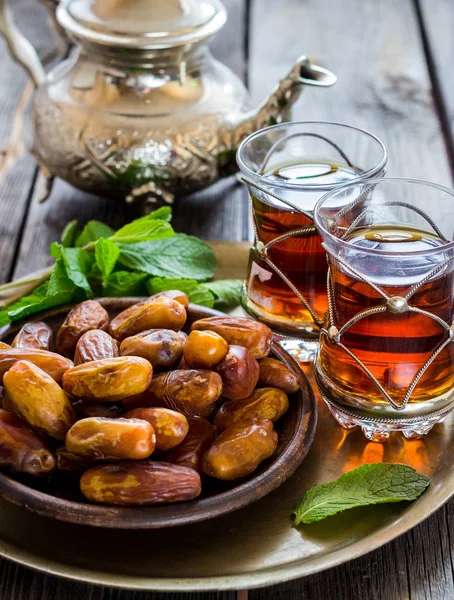 Čaj s mátou v arabské styl a data na dřevěný stůl. — Stock fotografie