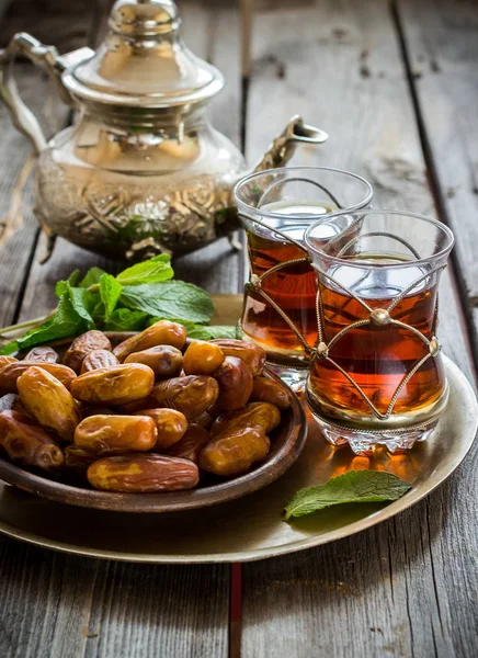 Te med mynta i arabisk stil och datum på träbord. — Stockfoto
