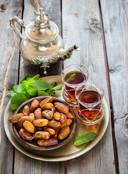 Thee met munt in Arabische stijl en datums op houten tafel. — Stockfoto