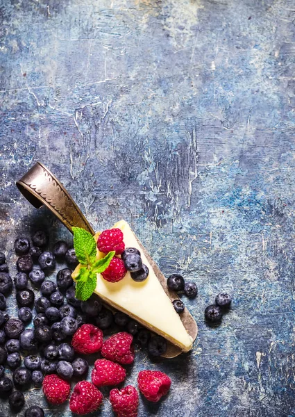 Cheesecake with berries on blue slate background. — Stock Photo, Image