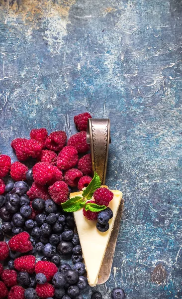 Cheesecake with berries on blue slate background. — Stock Photo, Image