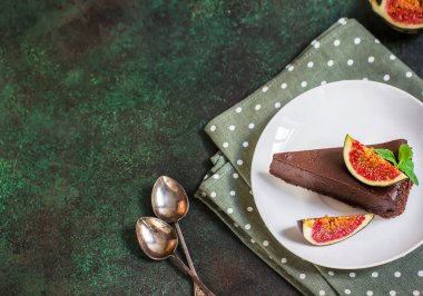 Yeşil arduvaz arka plan üzerinde incir ile Çikolatalı cheesecake. 