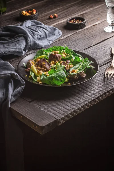 Зеленый салат с печенью и шпинатом на темном деревенском фоне . — стоковое фото