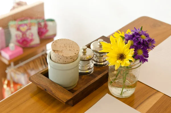 Wooden table in coffee shop with flower arrangement and salt & pepper and sugar