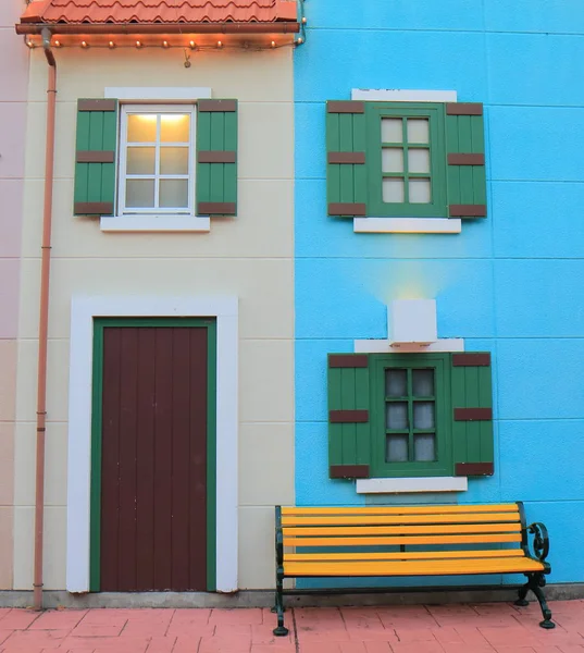 Colorida casa con banco amarillo —  Fotos de Stock