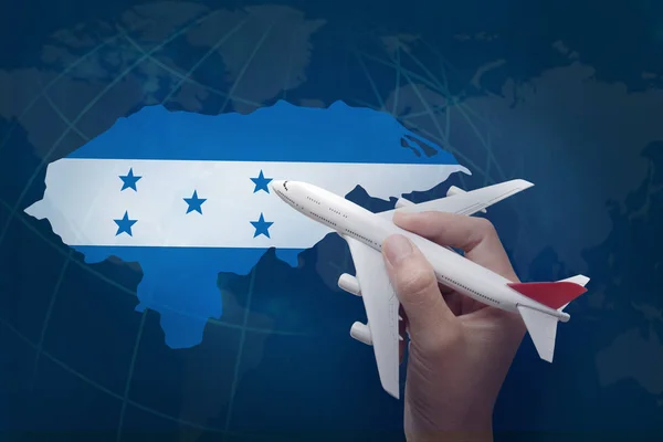 Hand holding airplane with map of Honduras. — Stock Photo, Image