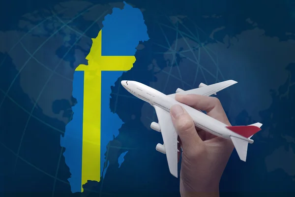 スウェーデンの地図が付いている飛行機を持っている手. — ストック写真