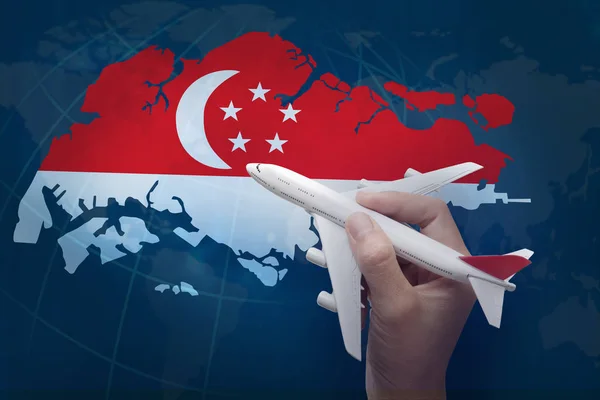 Tangan memegang pesawat dengan peta Singapura . — Stok Foto