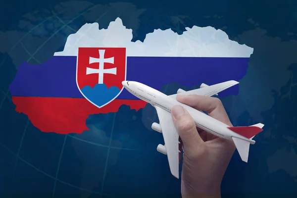 hand holding airplane with map of Slovakia.