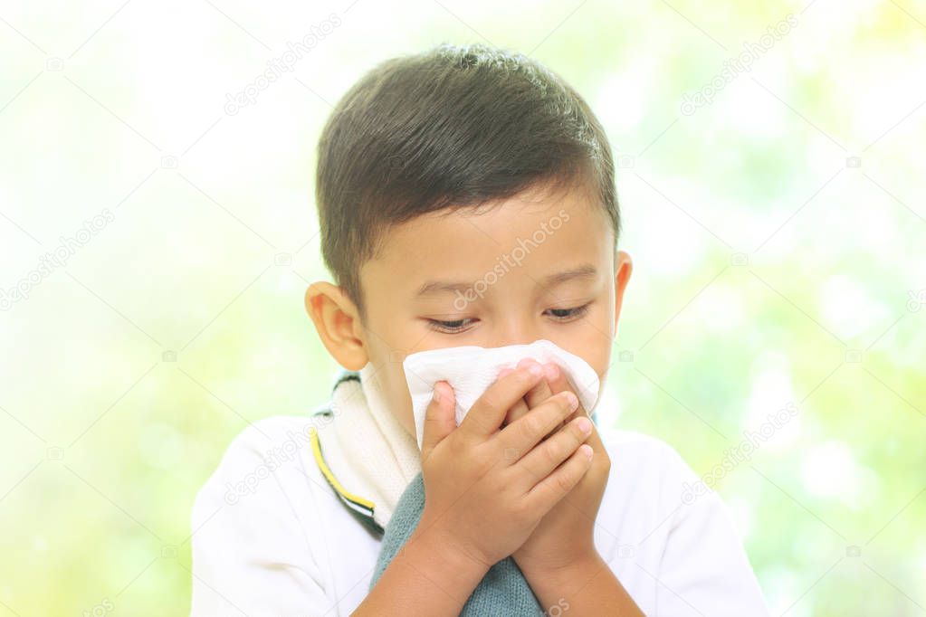 Little boy blowing his nose into tissue. healthcare and medical concept.