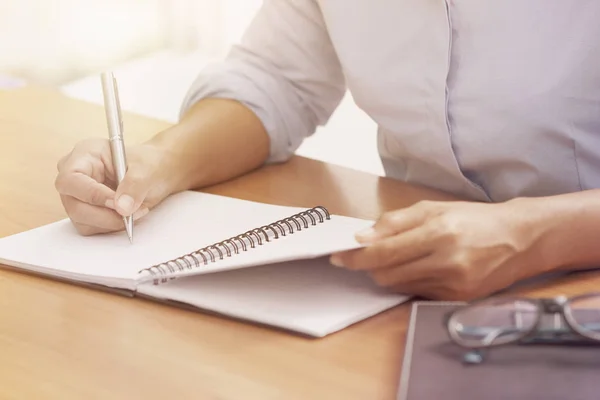 Business kvinna hand skriva på anteckningsboken på kontoret — Stockfoto