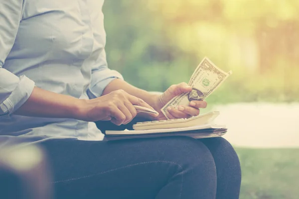 Mujer de negocios usando calculadora contando dinero y tomando notas Fotos De Stock Sin Royalties Gratis
