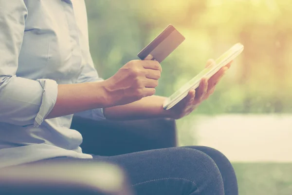 Jeune femme d'affaires mains tenant une carte de crédit et utilisant la table — Photo