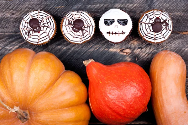 Halloween-Hintergrund. Kürbis-Muffins und Kuchen auf rustikalem Holztisch. Schokoriegel für die Halloween-Party — Stockfoto