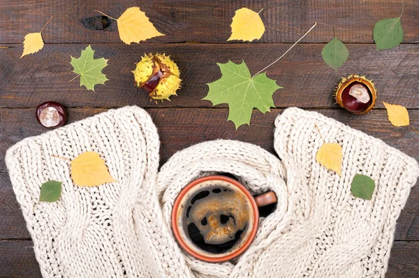 Taza de café caliente, bufanda de lana hecha a mano y castañas sobre fondo de madera. Ropa de otoño o invierno. Concepto acogedor ambiente de otoño con una taza de café. Copiar espacio — Foto de Stock