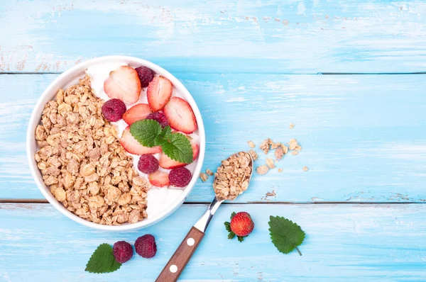 Hälsosam frukost - granola med bär, yoghurt och mjölk på blå trä bakgrund. Begreppet hälsosam livsstil, äta och kost. Ovanifrån — Stockfoto