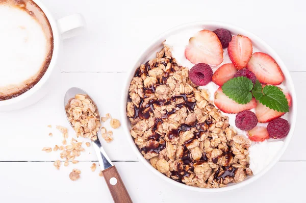 Havremjöl müsli till frukost med bär, yoghurt och choklad på vit trä bakgrund. Sunda matvanor — Stockfoto