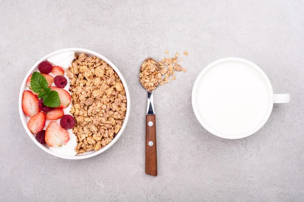 Müsli till frukost med bär, yoghurt och mjölk på grå sten bakgrund. Hälsosam kost havregryn. Begreppet hälsosam livsstil och kost — Stockfoto