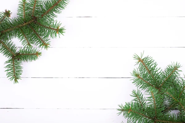 Sfondo natalizio. Albero di Natale su tavola di legno bianco. Ramo di abete. Vista dall'alto — Foto Stock