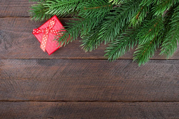 Kerstcadeau en kerstboom op houten achtergrond. Kopiëren van ruimte — Stockfoto
