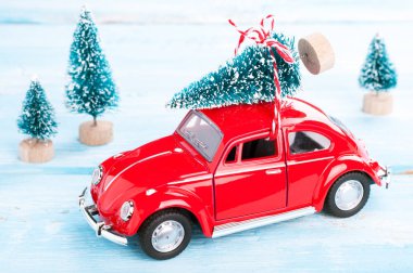 Kırmızı araba ile Noel ağacı minyatür herdem yeşil orman içinde. Noel arka plan