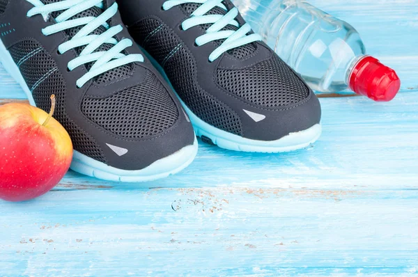 Equipamiento deportivo y zapatillas deportivas. Zapatos deportivos, manzana, botella de agua. Concepto estilo de vida saludable, comida saludable, deporte y dieta — Foto de Stock