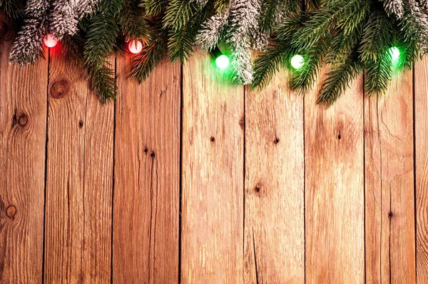 Spar kerstboom met kleurrijke lichten op donkere houten achtergrond. Kerstmis achtergrond met kopie ruimte — Stockfoto