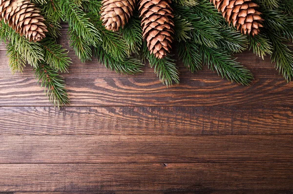 Kerstmis achtergrond. Kerstboom met decoratie en pinecones op oude houten achtergrond. Xmas card. Bovenaanzicht — Stockfoto