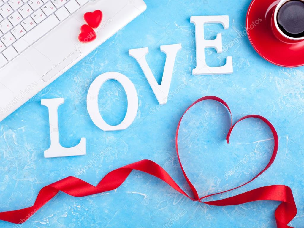 Valentines background with red heart, coffee cup and laptop. Valentines Day greeting card. Female workplace
