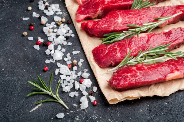 Carne cruda sobre fondo oscuro. Estroganoff de carne cruda con hierbas y especias de cerca. Cocinar carne —  Fotos de Stock