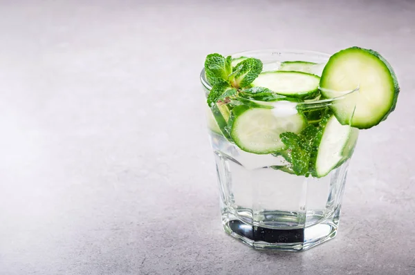 Água mineral fria e refrescante com pepino e hortelã. Bebida de verão. Conceito de bebida saudável e desintoxicação — Fotografia de Stock