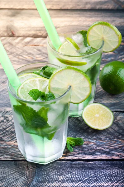 Coquetel de limão Mojito no bar na mesa rústica. Ingredientes para fazer mojito. Bebida refrescante de verão. Imagem tonificada — Fotografia de Stock