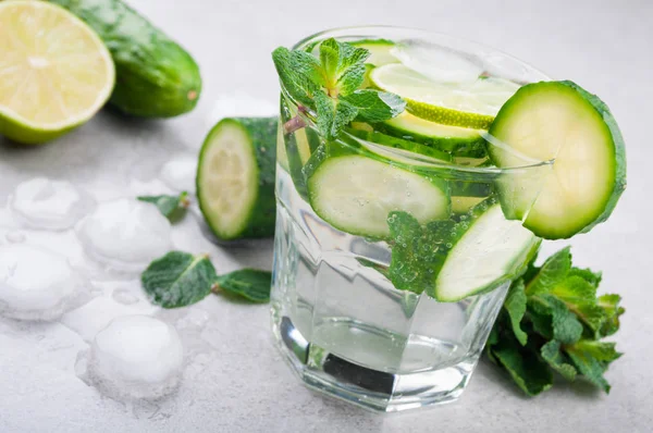 Agua refrescante con pepino, menta y hielo sobre fondo gris. Bebida de verano pepino limonada — Foto de Stock