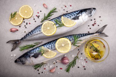 Fresh raw fish. Mackerel with salt, lemon and spices on gray background. Cooking fish with herbs clipart