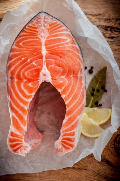 Rauwe zalm vissen biefstuk met citroen en kruiden op houten rustieke achtergrond. Verse vis — Stockfoto