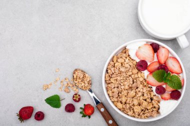 Granola, meyve, yoğurt ve süt gri taş zemin üzerine Odaya Servis Kahvaltı. Yulaf ezmesi yeme sağlıklı. Kavram sağlıklı yaşam tarzı ve diyet