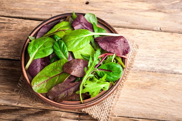 Frischer grüner Salat mit Spinat, Rucola, Mangoldblättern, Salat. gemischte Salatblätter auf rustikalem Holzgrund. gesunde Ernährung, gesunder Lebensstil und Ernährungskonzept — Stockfoto
