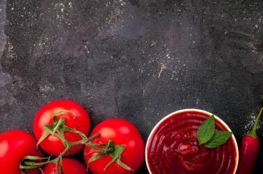 Bir kase chili, Bazilika ve domates domates ketçap sosu. Ketçap koyu arka plan üzerinde yemek pişirmek için malzemeler