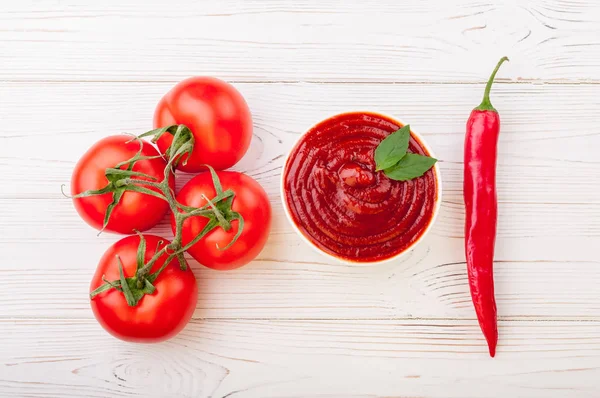 Tomaten ketchup saus in een kom met chili, basilic en tomaten. Ingrediënten voor het koken van ketchup — Stockfoto