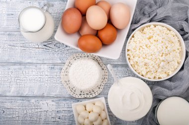 Süt ürünleri ahşap masa üzerinde. Süt, krema, peynir, yumurta, yoğurt ve tereyağı. Sağlıklı gıda, beslenme kavramı